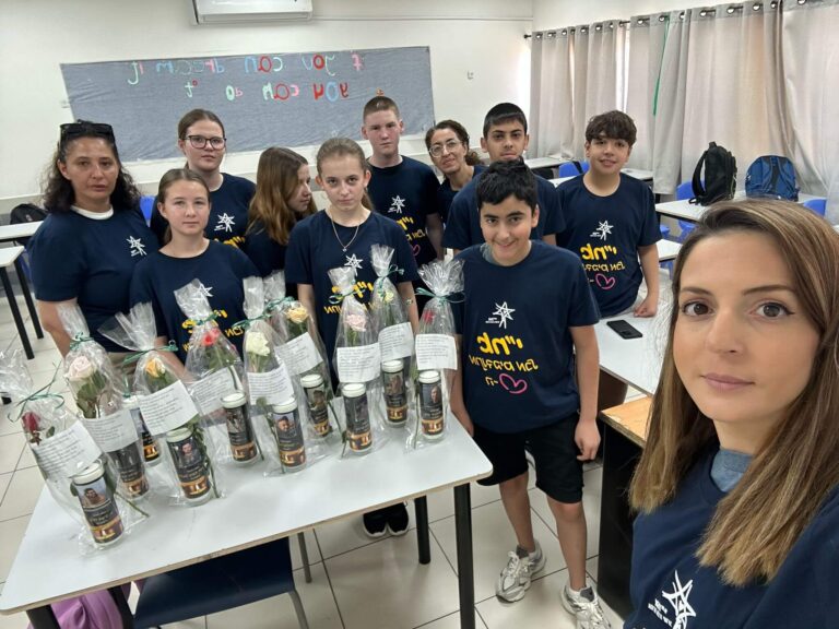 קבוצת נערים וצוות בית הספר בפעילות ערכית למען חללי מלחמת חרבות ברזל