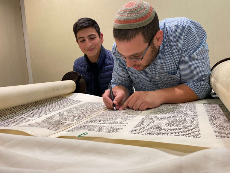 2 אנשים כותבים אותיות בספר תורה