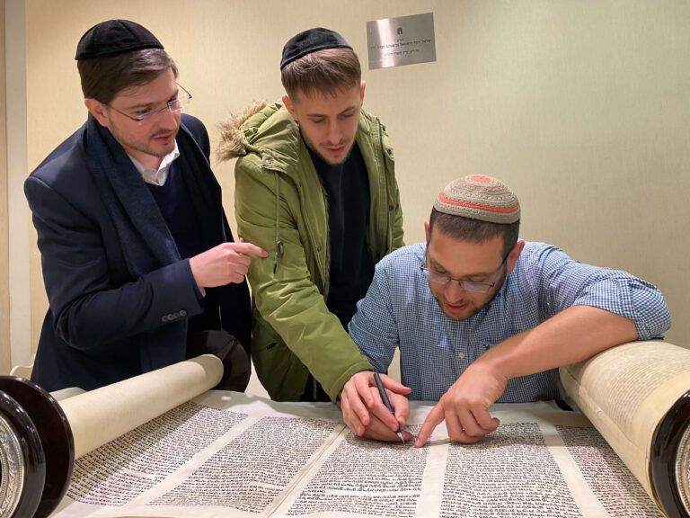 3 אנשים כותבים אותיות בספר תורה