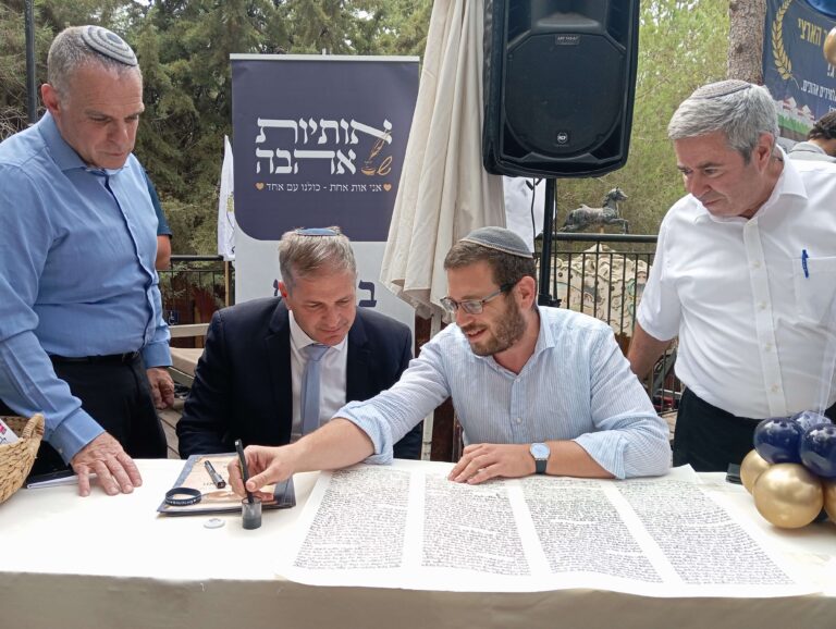 4 אנשים כותבים אותיות בספר תורה