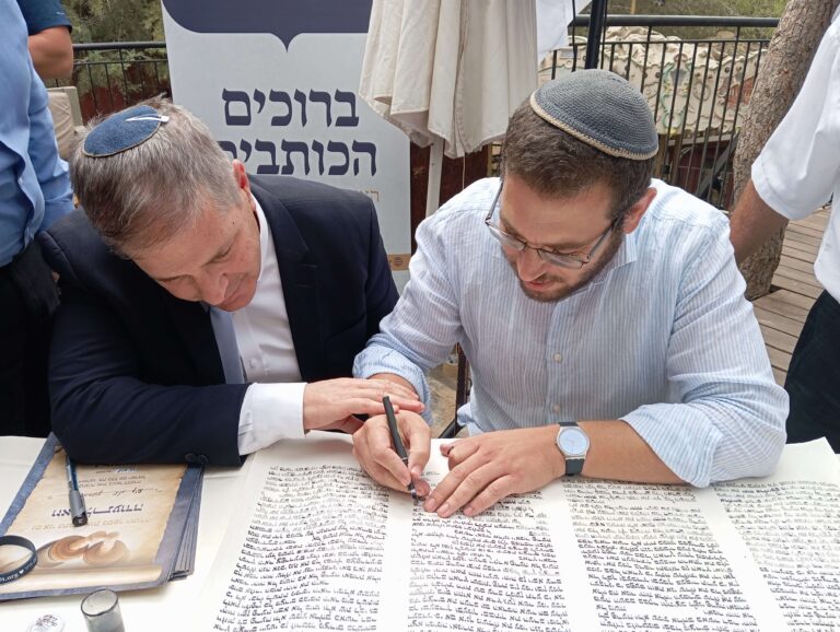 2 אנשים כותבים אותיות בספר תורה