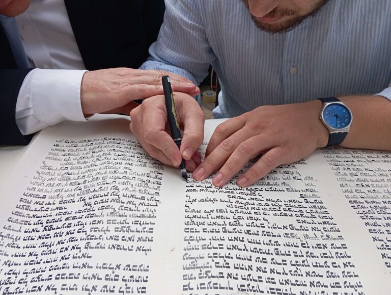 2 אנשים כותבים אותיות בספר תורה