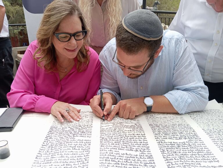 2 אנשים כותבים אותיות בספר תורה