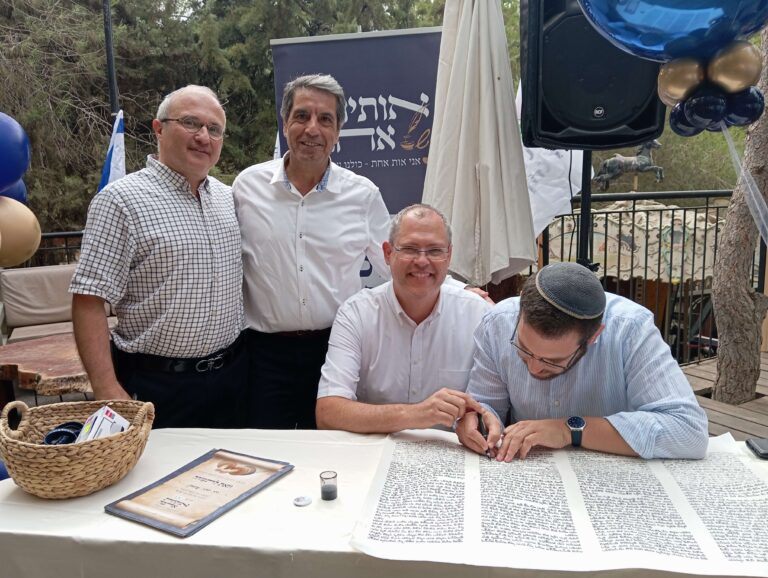 4 אנשים כותבים אותיות בספר תורה