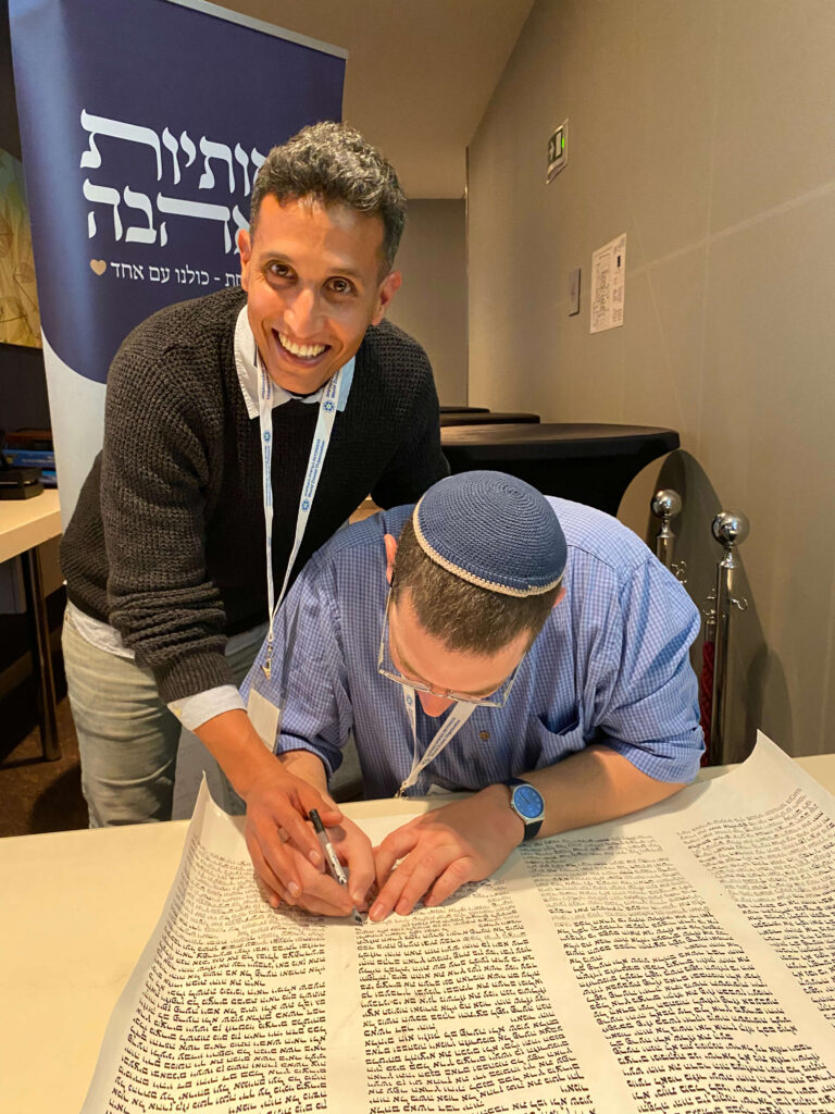 2 אנשים כותבים אותיות בספר תורה