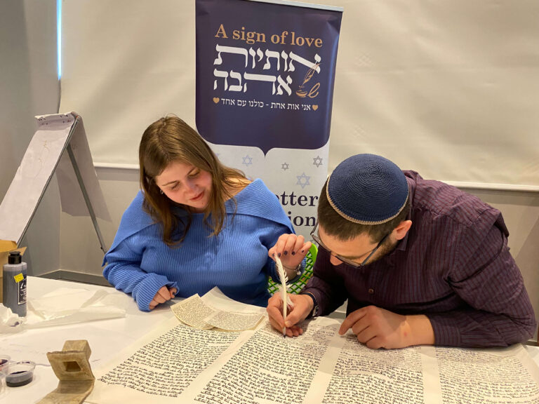 2 אנשים כותבים אותיות בספר תורה